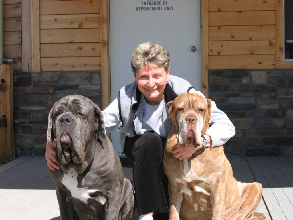 A picture of a woman flanked by her two large dogs